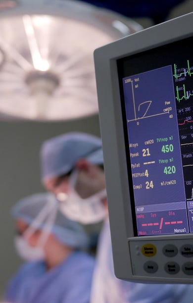 Hospital operating room with monitor and IV bag in foreground